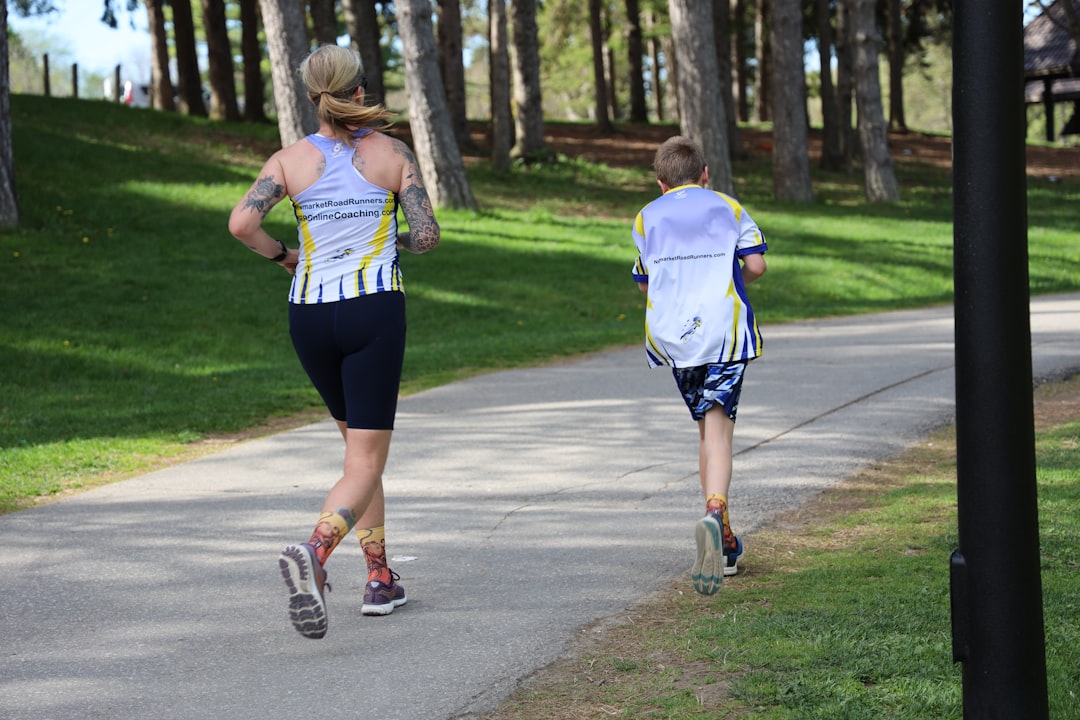 A parent and child jogging together on a trail, representing a youth sports A-Thon fundraiser