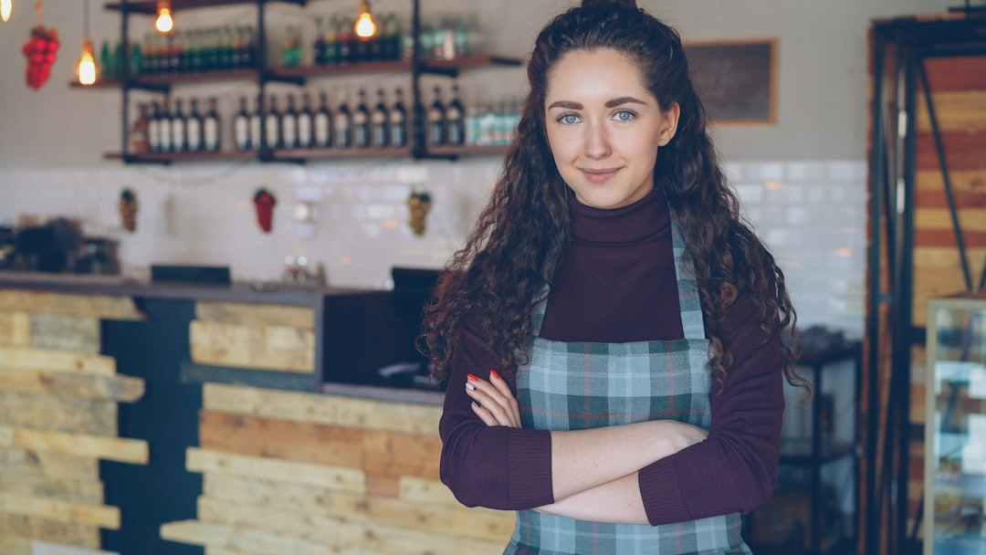 Small business owner smiling in her shop, a potential long-term team sponsor