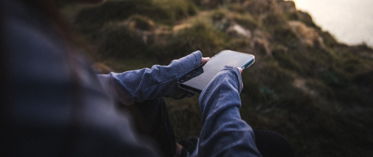 Person using a smartphone outdoors to post on social media