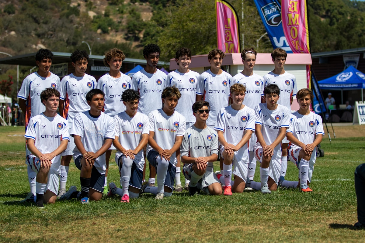 Youth soccer team posing together on a sunny field before a tournament