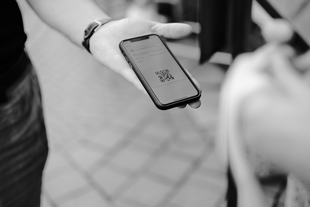 Parent holding a phone to make a quick donation at a youth sports game