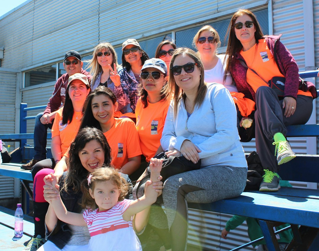 Group of parents and a child sitting together on bleachers at a youth sports game