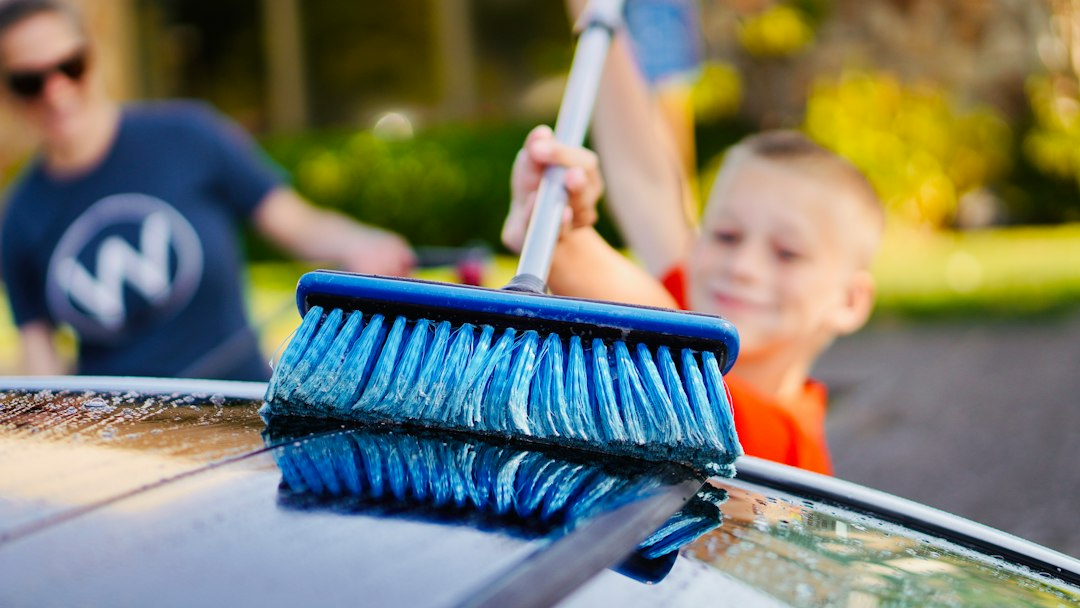 A young athlete washing a car as part of a team car wash fundraiser